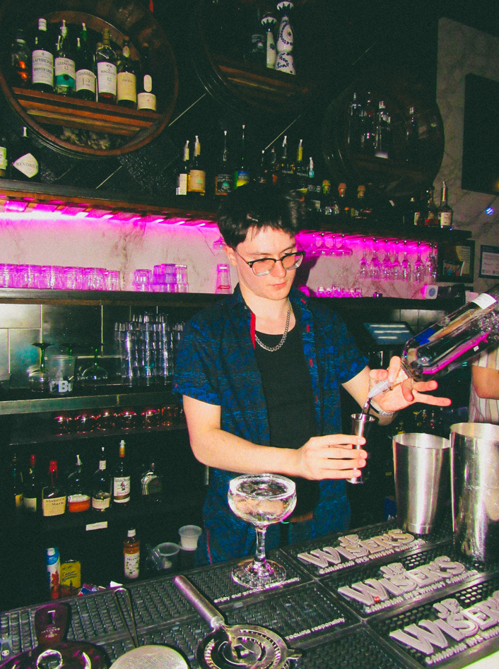 Photo of Ethan Buckarev at work pouring a drink.